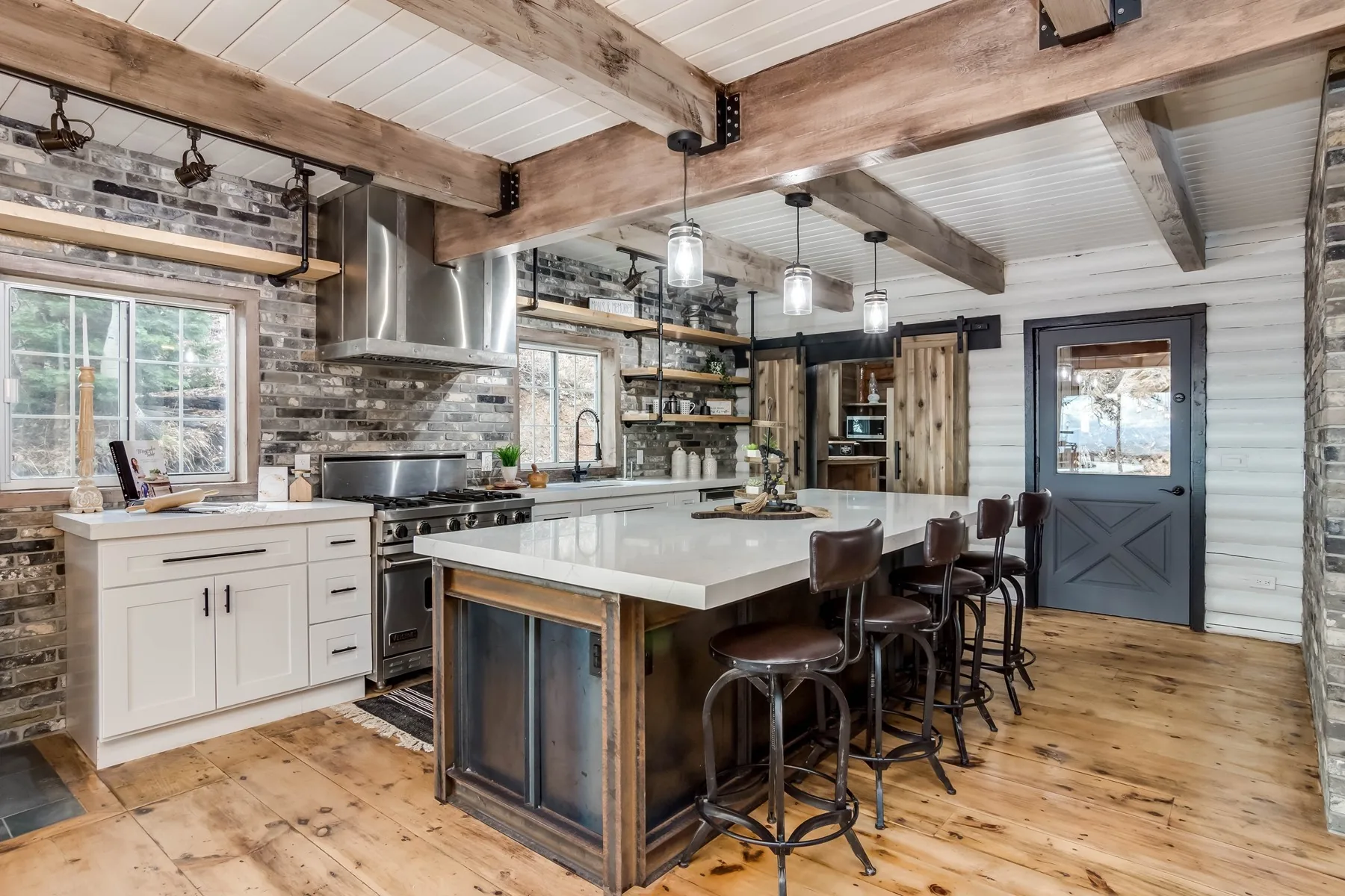 Remodelled kitchen with exposed brick, reclaimed beams and a quartz island