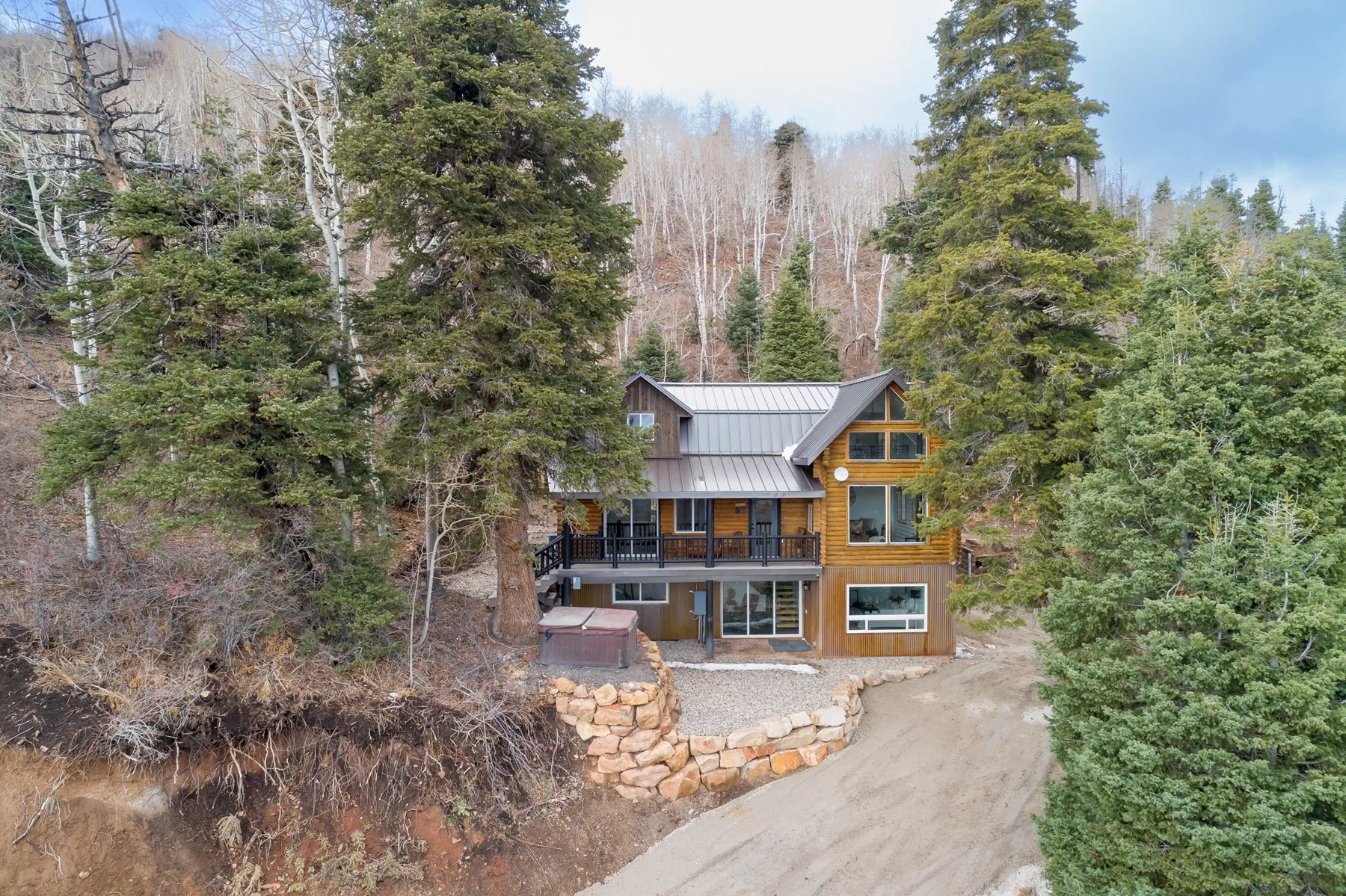 Aerial view of the remodelled Stagecoach log home on its wooded mountain lot